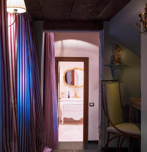 a hallway with a bathroom with a mirror and a chair at Hotel Heureka in Venice
