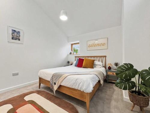 a bedroom with a bed and a potted plant at Damson Barn in Bluntisham