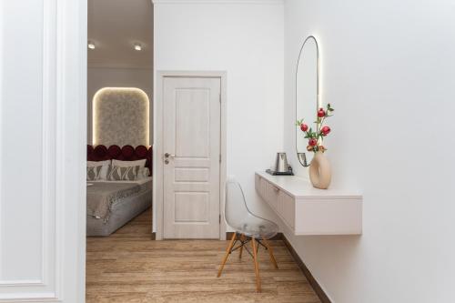ein weißes Badezimmer mit Waschbecken und Spiegel in der Unterkunft Alex Hotel in Yerevan