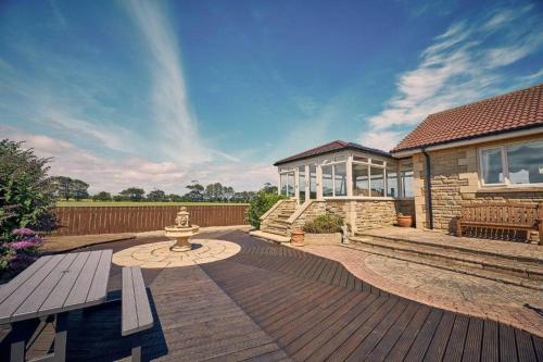 a wooden deck with a fire hydrant in front of a house at Host & Stay - Cheviot View in Seahouses