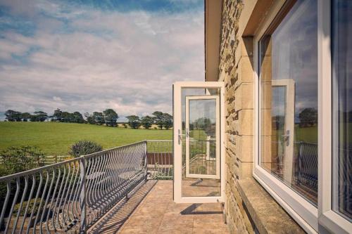 a balcony with a view of a green field at Host & Stay - Cheviot View in Seahouses