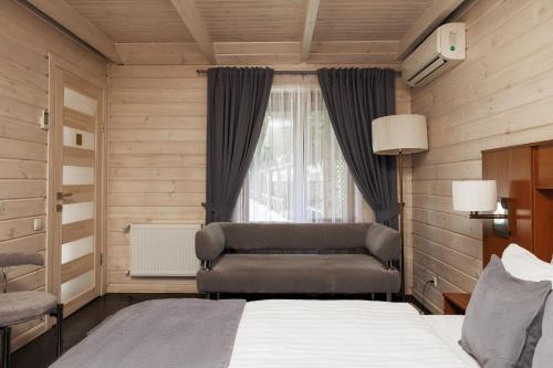 a bedroom with a bed and a chair and a window at Hotel 4x4 in Rivne