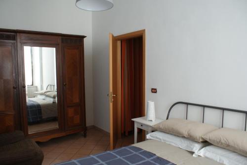 een slaapkamer met een bed, een dressoir en een spiegel bij Casa Elisa in Cosenza