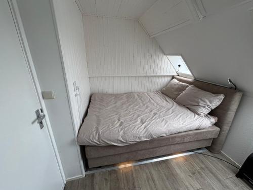 a small room with a bed in a small room at Waterzicht 3 in Uitwellingerga