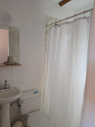 a white bathroom with a toilet and a sink at Casa Brisa Marina El Yaque in El Yaque