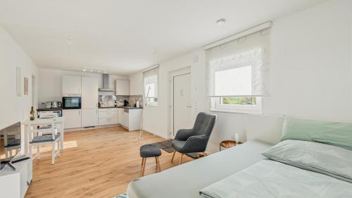 a white bedroom with a bed and a kitchen at Apartment am Fuchseck in Schorndorf