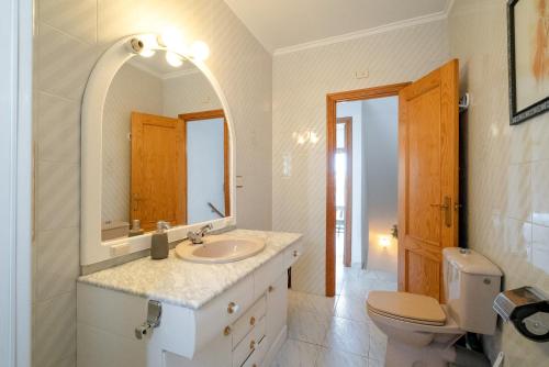a bathroom with a sink and a toilet and a mirror at Casa dos mares in San Javier