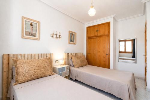 a bedroom with two beds and a window at Casa dos mares in San Javier