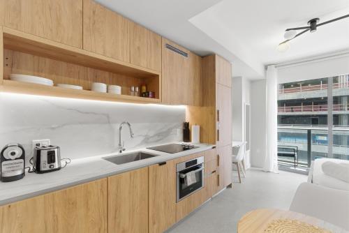 a kitchen with wooden cabinets and a sink at Downtown Studio Steps from Kaseya Center in Miami