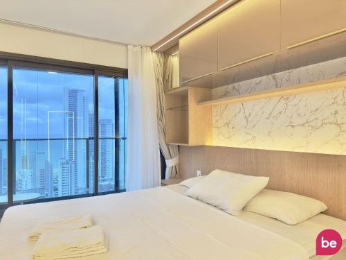 a bedroom with a large bed with a large window at Beach Class Meireles in Fortaleza