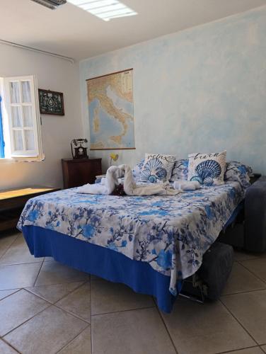 a bedroom with a bed with a blue comforter at Indigo Moon in Quartu SantʼElena