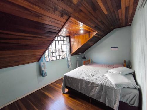 a bedroom with a large bed with a wooden ceiling at Recanto do Sabiá Center in Chapecó