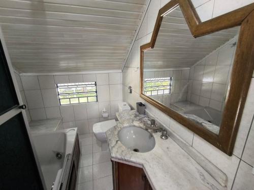 a bathroom with a sink and a mirror at Recanto do Sabiá Center in Chapecó