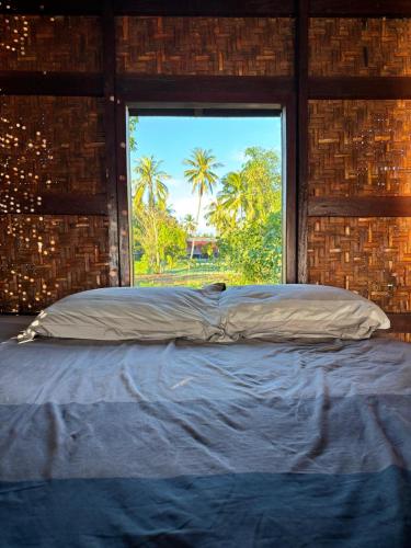 a large bed in a room with a window at Don Som Riverside Guesthouse in Don Som