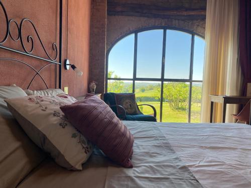 a bedroom with a bed with a large window at Tempo al Tempo in Villadeati