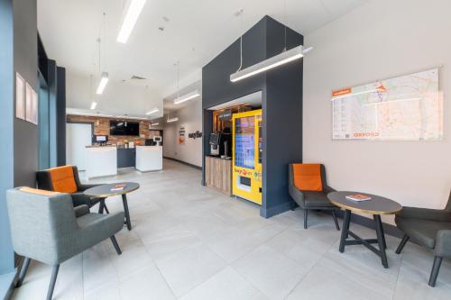a waiting room with chairs and tables in a office at easyHotel Oxford in Oxford