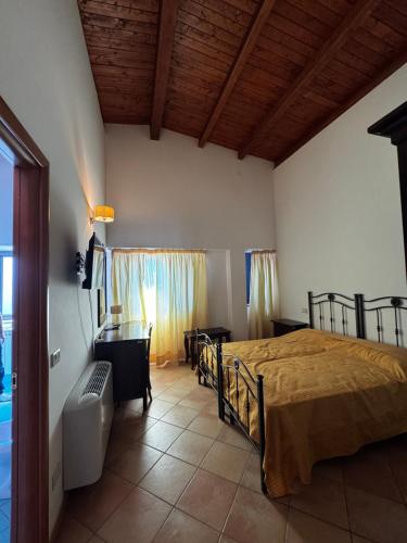 a bedroom with a bed and a desk and a window at La terrazza del cilento in Perito