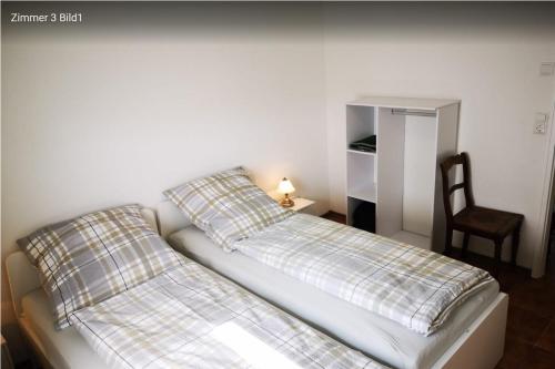 a bedroom with two beds and a chair in it at Haus Birkenblick in Rimbach