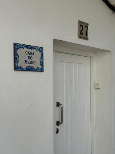 a door with a sign above it and a sign above it at Casa do medio in Corcubión