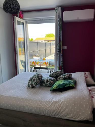 a bed with pillows on it in a room with a window at Petit gîte a côté des plages in Triaize