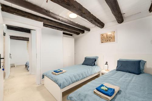 two beds in a room with white walls and wooden ceilings at Villa Amanda by CVR in Roústika