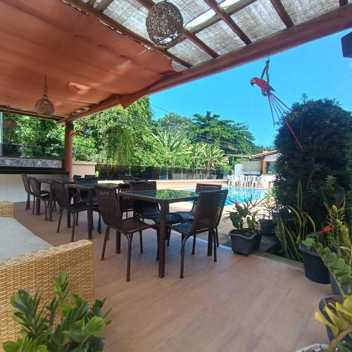 a patio with a table and chairs and a pool at Mestre Lord Apart Hotel 300m Praia Taperapuã by La Vem Férias in Porto Seguro