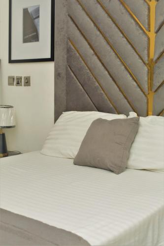 a bedroom with a white bed with a gray headboard at Top city Homes in Lagos