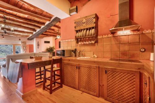 a kitchen with orange walls and a counter with a sink at Casa Alfurán in Alfornón