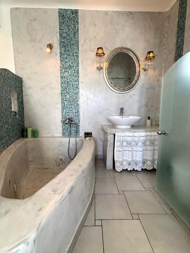 a large bathroom with a tub and a sink at Villa Galathea in Kamari