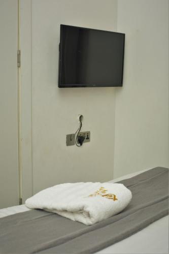 a flat screen tv hanging on a wall with a bed at Top city Homes in Lagos