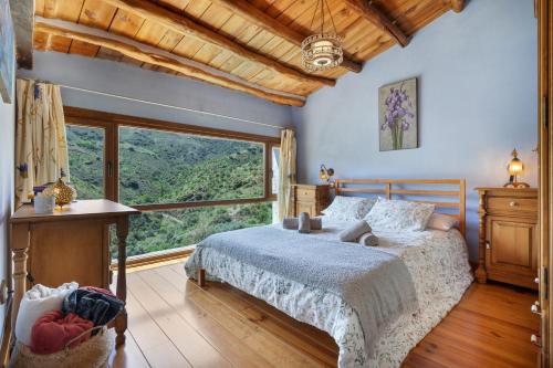 a bedroom with a bed and a large window at Casa Alfurán in Alfornón
