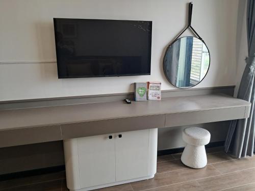 a desk with a tv and a mirror at Homestay- Phòng nghỉ Lazur Cửa Lò in Giáp Vinh Yên