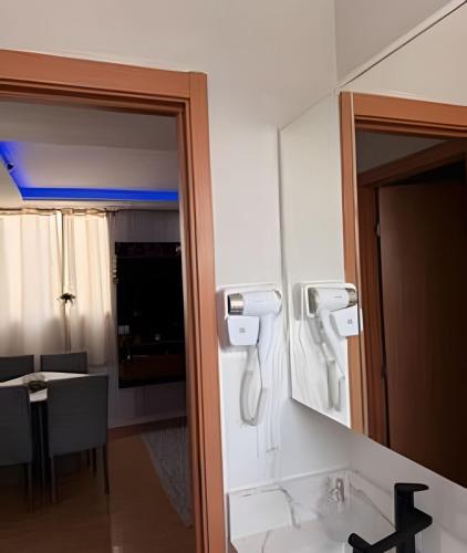 a bathroom with a mirror and a phone on the wall at Safiras Premium | Seu conforto em Cuiabá in Cuiabá
