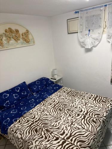 a bedroom with a bed with a zebra print sheets at Casa Ady in San Teodoro