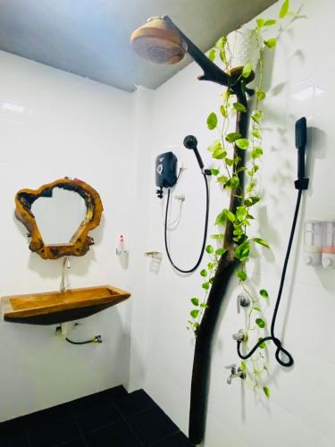 a bathroom with a shower with a plant next to it at Mango Tree House Yala Safari Hotel in Tissamaharama