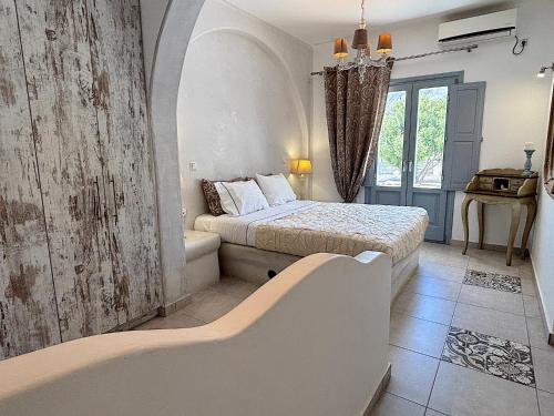 a bedroom with a bed and a tub in it at Villa Galathea in Kamari