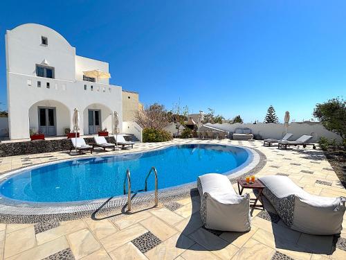 a swimming pool in front of a villa at Villa Thea in Kamari