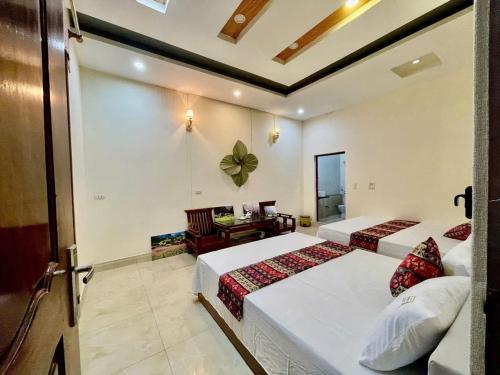a bedroom with two beds and a desk in it at Su Ha Giang Hostel in Ha Giang