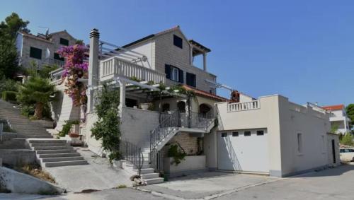 a white house with stairs and a garage at House Postira Horizon in Postira