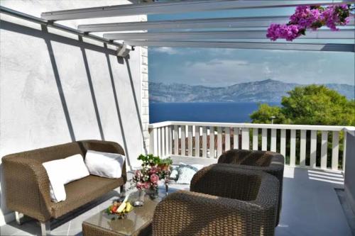 two chairs on a balcony with a view of the water at House Postira Horizon in Postira