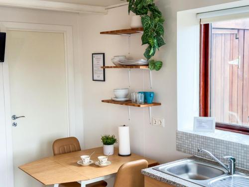 a small kitchen with a sink and a table at Fagrahlid Guesthouse in Hvolsvöllur