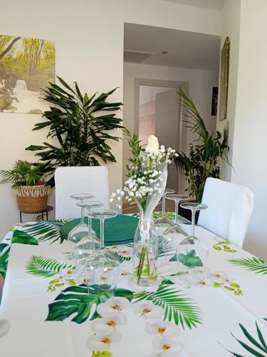 a table with a white table cloth with flowers and glasses at Appartment Lodged Mamma Maria in Mattarello