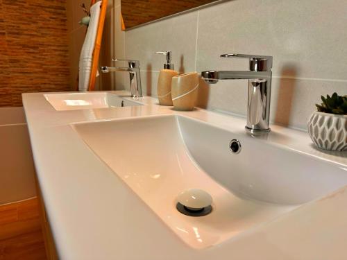 a white sink with two faucets on a counter at Sítio D'Elvas in Elvas