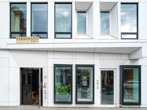 a facade of a white building with glass doors at Ferdinand Boutique in Cluj-Napoca