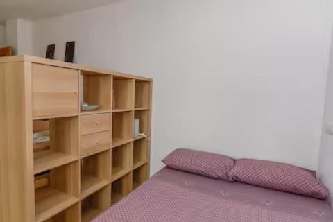 a bedroom with a book shelf and a purple bed at Aprt ESTUDIO ARRIXACA in Murcia