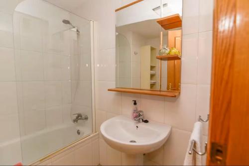 a white bathroom with a sink and a shower at Aprt ESTUDIO ARRIXACA in Murcia