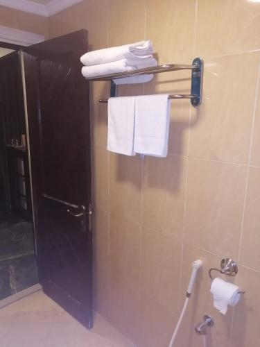 a bathroom with a shower with towels on a wall at Hotel Grand Peshawar in Peshawar