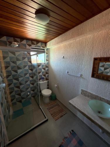 a bathroom with a shower and a sink and a toilet at Pousada Casa do Telhado Verde in Cabo Frio