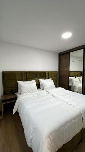 a large white bed in a bedroom with a large mirror at Luxury Villa Grey in Široki Brijeg