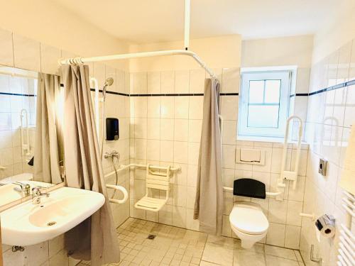 a bathroom with a sink and a toilet and a shower at Diekstuv Hotel in Jork